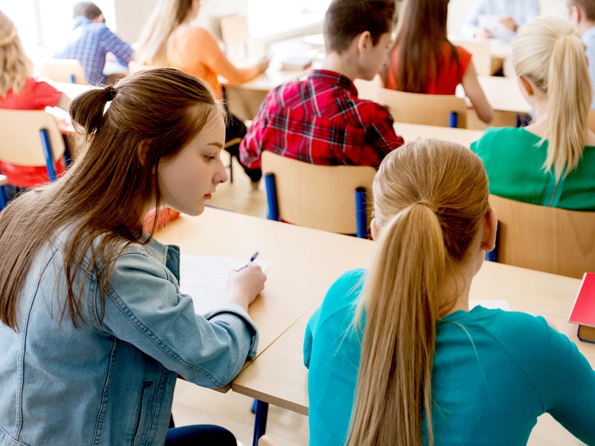 Klassenraum mit Schülerinnen und Schülern, die gerade an zweier Teamaufgaben sitzen.