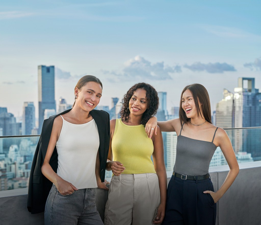 Drei junge Frauen tragen die Unqlo BH-Tops und posieren auf eine, Balkon.