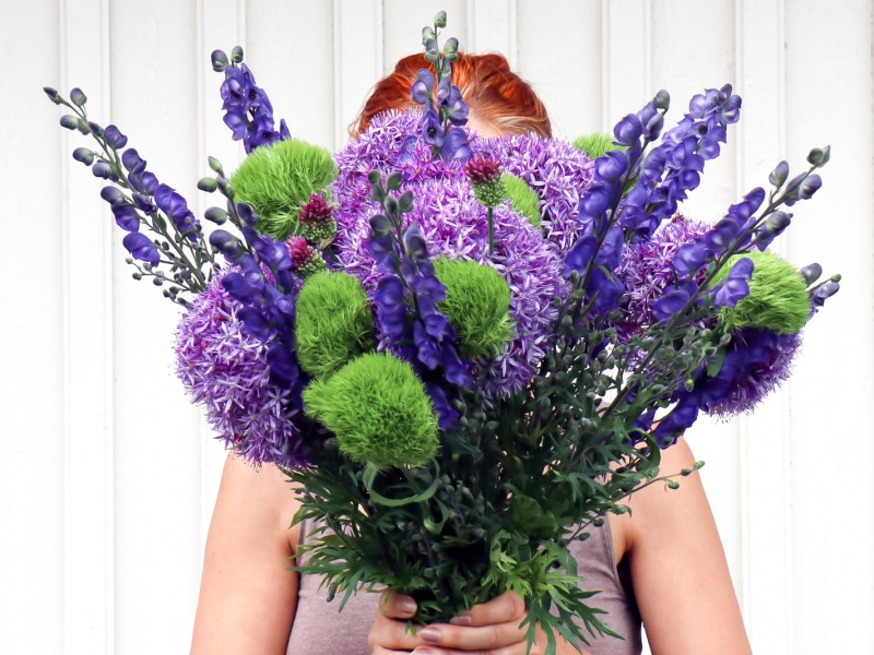 Frau mit Blumenstrauß, unter anderem Allium.