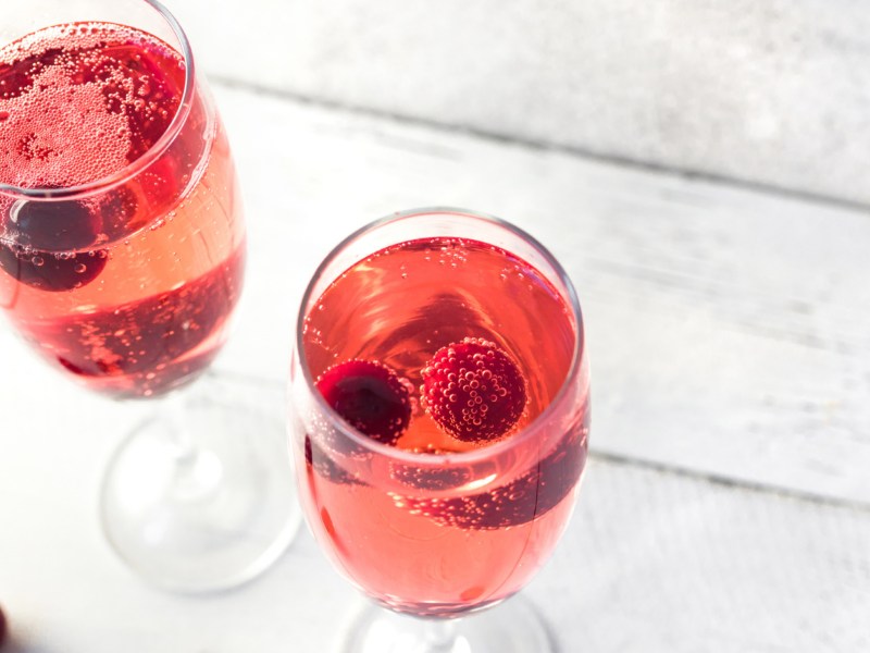 Champagnerglas mit Kir Royal und Himbeeren.