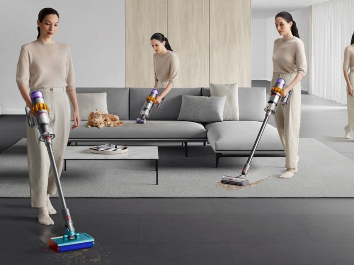 Frau saugt Teppich, Boden und Sofa mit Dyson Staubsauger.