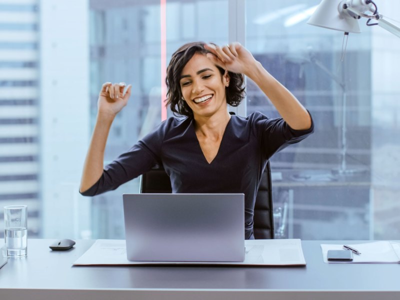 Frau freut sich vor Laptop