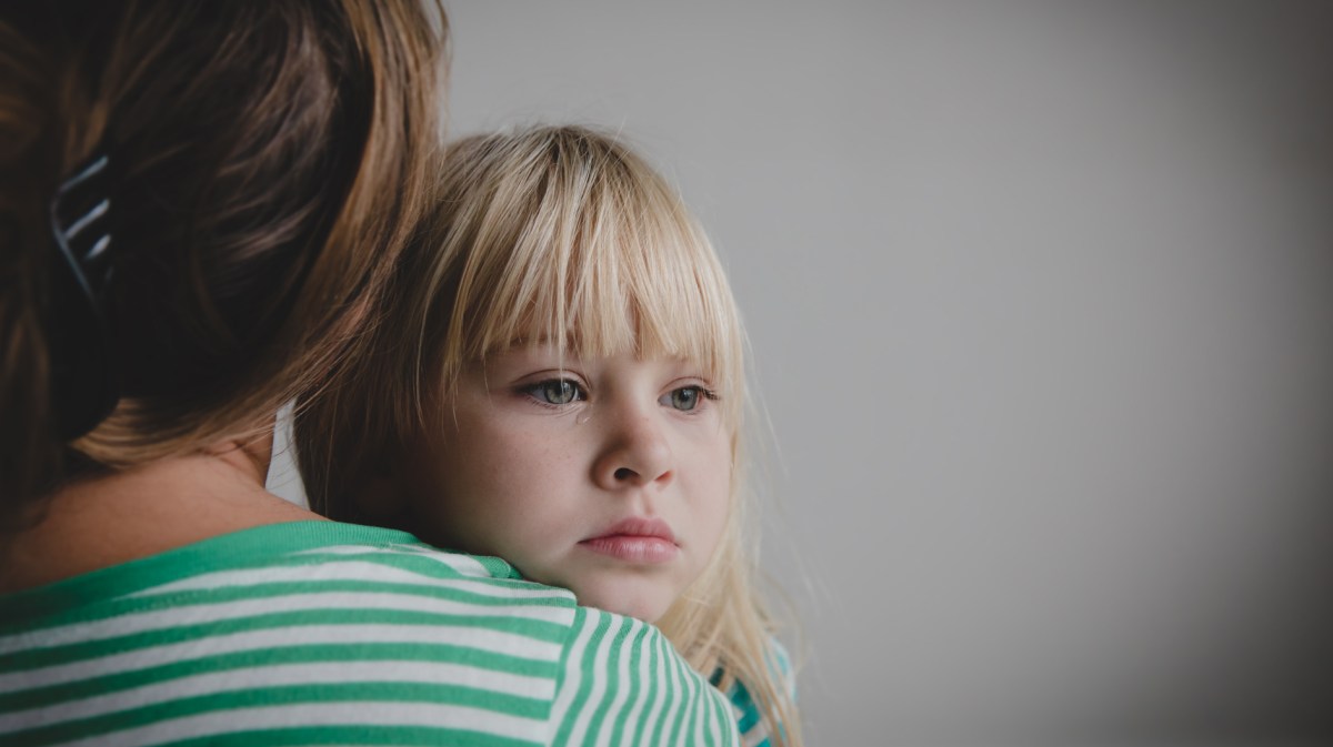 Mädchen, ca. 6 Jahre alt, mit verweinten Augen, wird von ihrer Mama getröstet.