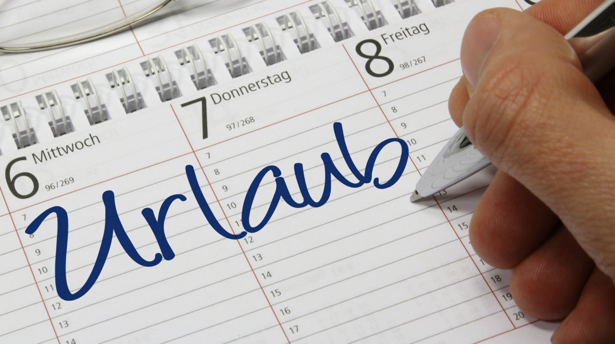 Person schreib „Urlaub“ in seinen Terminkalender