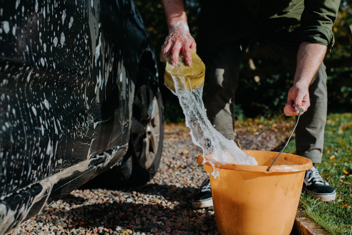 Mann beim Auto waschen