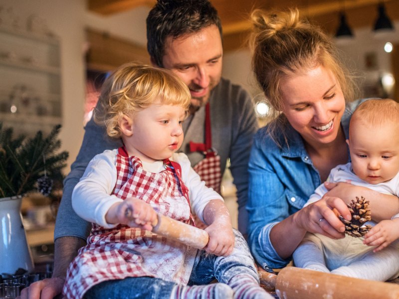 Junge Familie backt in der Weihnachtszeit Plätzchen zu Hause.