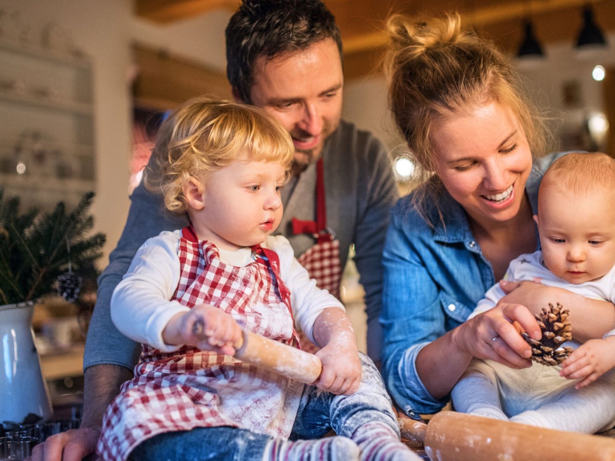 Junge Familie backt in der Weihnachtszeit Plätzchen zu Hause.