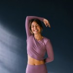 Frau in lila Sportkleiung lächelt