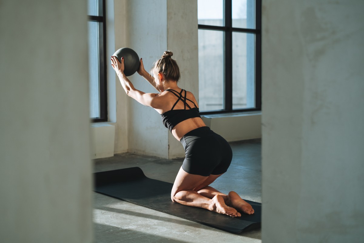 Frau trainiert mit Pilates Ball