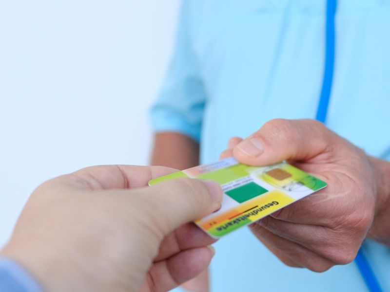 Person übergibt eine Krankenkasse