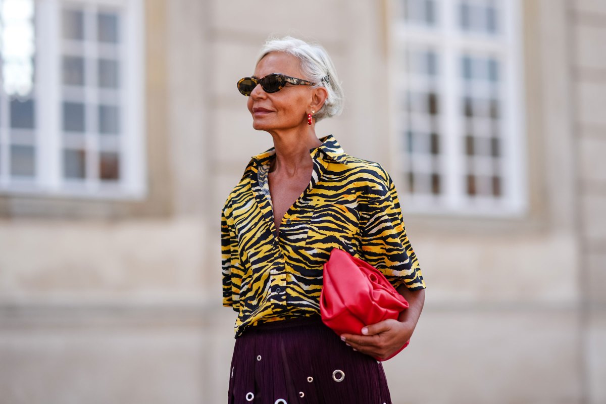 Grece Ghanem trägt eine Bluse mit Tigermuster und dazu einen violetten Rock.