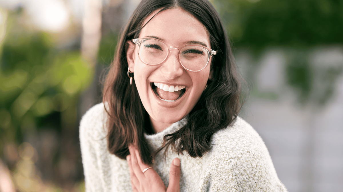 Frau mit Brille lächelt strahlend in die Kamera