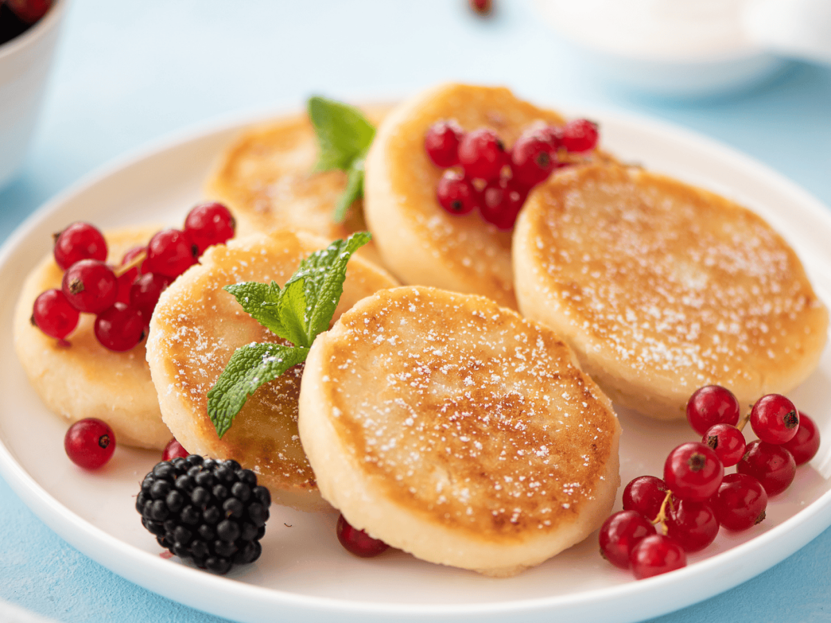 Kleine Pancakes auf einem weißen Teller.