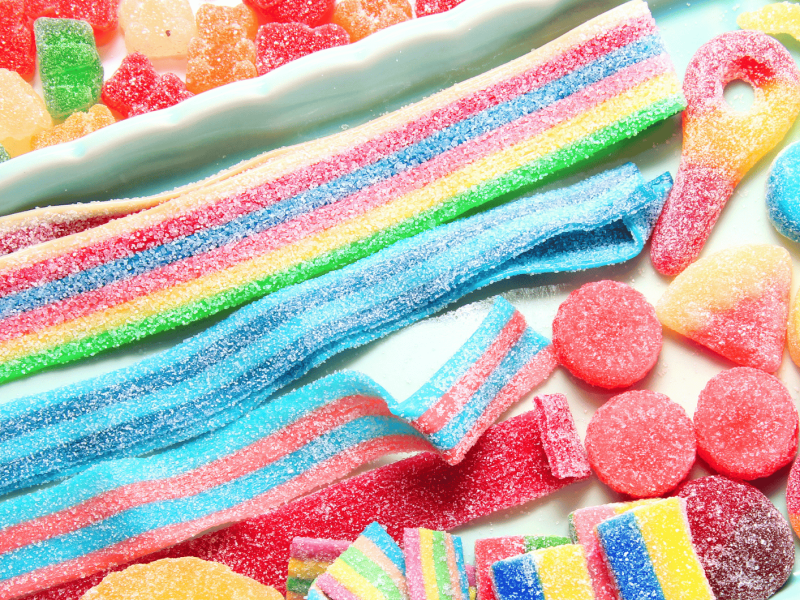 Verschiedene bunte Süßigkeiten auf weißem Untergrund.