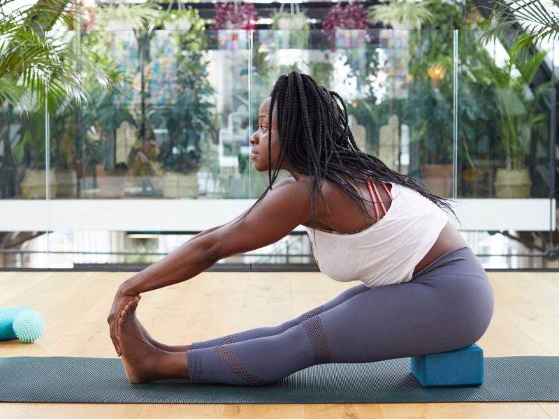 Frau streckt sich auf Yogamatte