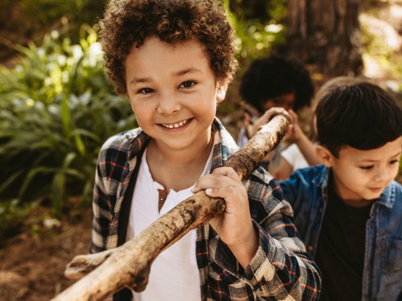 Kinder im Wald bauen etwas mit Stöckern.