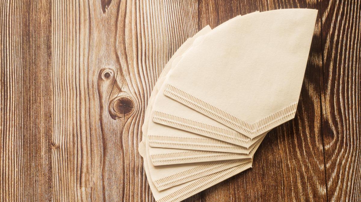 Kaffeefilter liegen auf einem Holztisch.