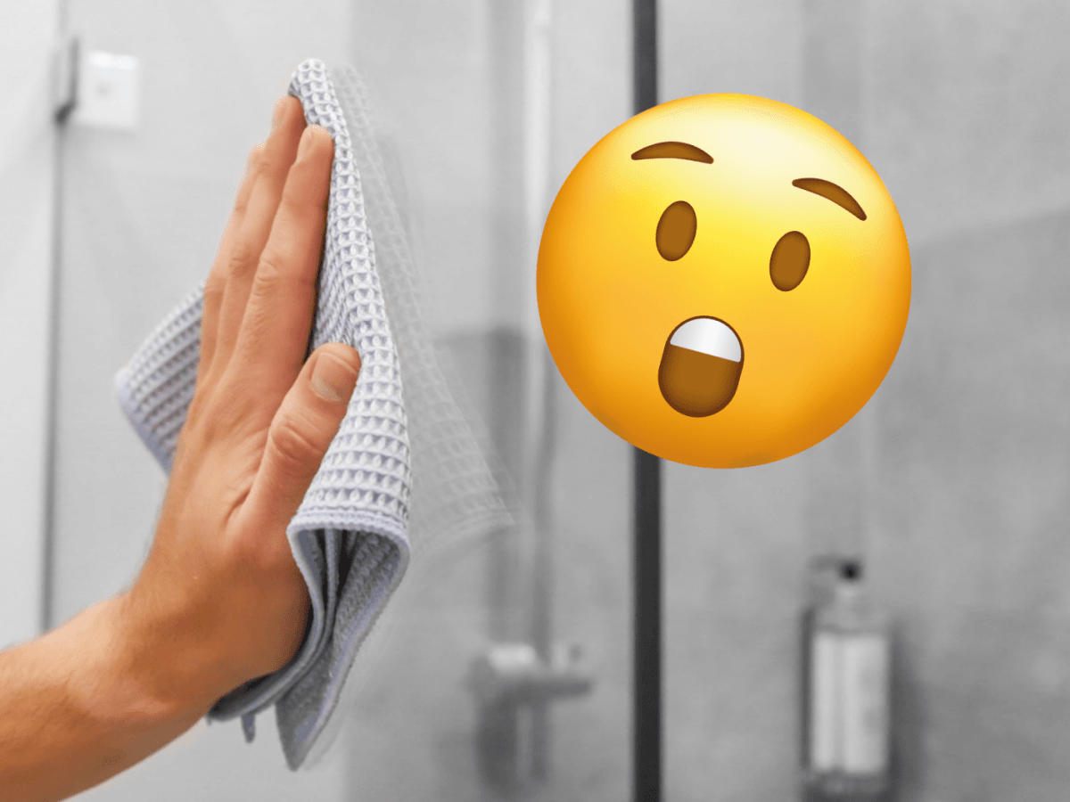Eine Person putzt eine glänzende Dusche mit einem Lappen