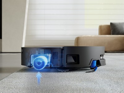 Schwarzer Saugroboter hebt automatisch eine innen leuchtend blau dargestellte Rolle an, um von Teppich auf glatten Boden zu wechseln.