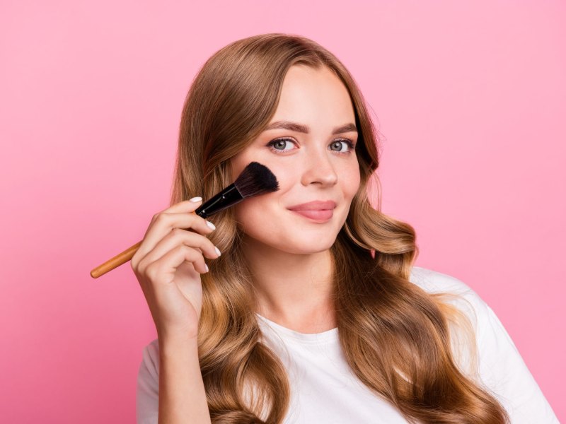 Frau mit soften Tages-Make-up vor rosa Hintergrund