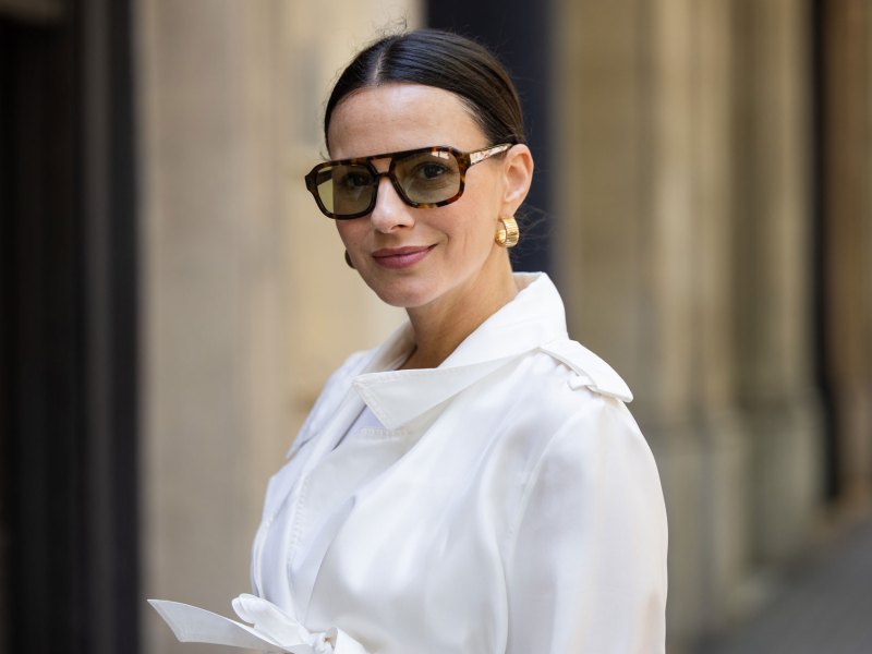 Frau mit weißer Bluse und brauner Sonnenbrille.