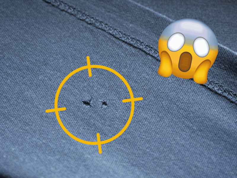 Blaues T-Shirt mit zwei Löchern, darauf ein gelber Fokus mit einem schockierten Emoji.