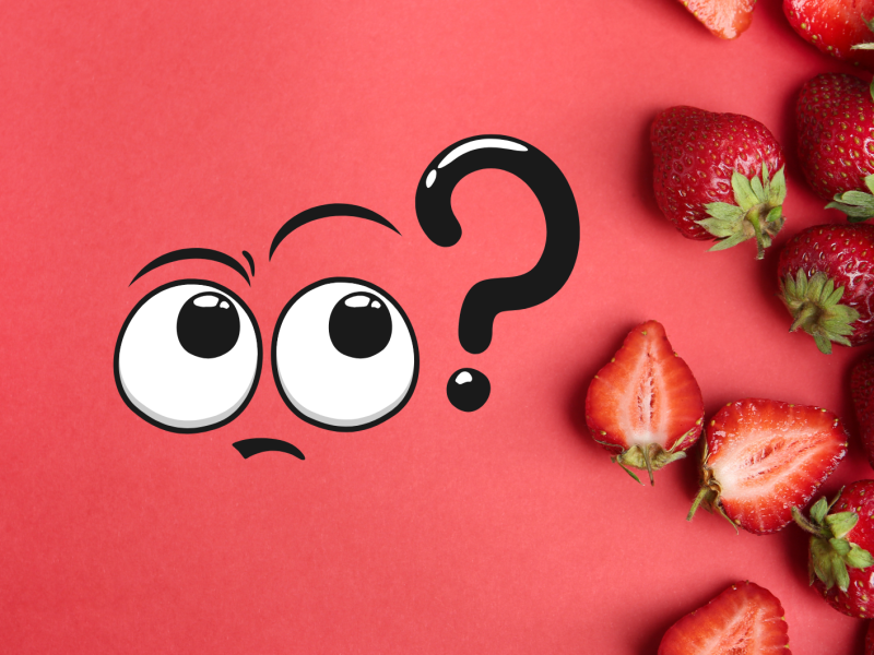 Erdbeeren liegen auf einem roten Untergrund. Und ein Fragezeichen steht daneben.