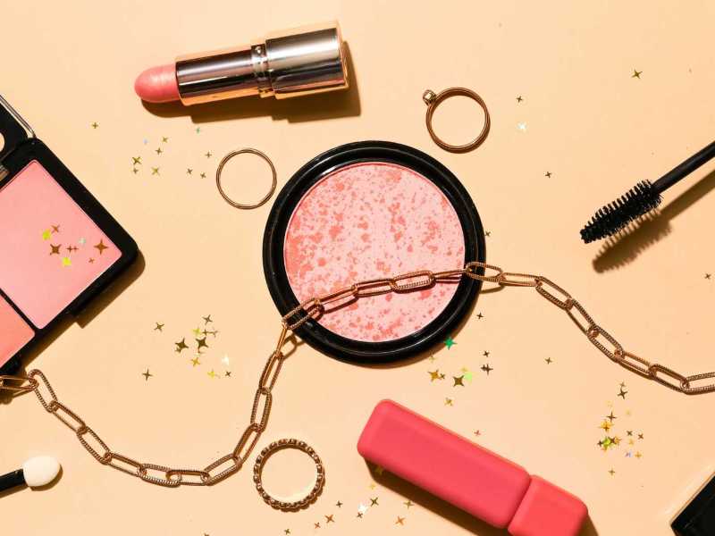 Schmuck und dekorative Kosmetik auf farbigem Hintergrund.