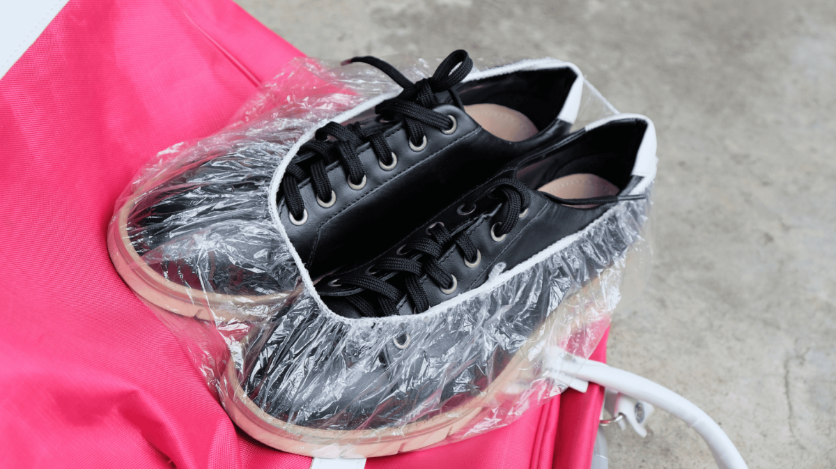 Schuhe sind in Duschhaube gepackt.