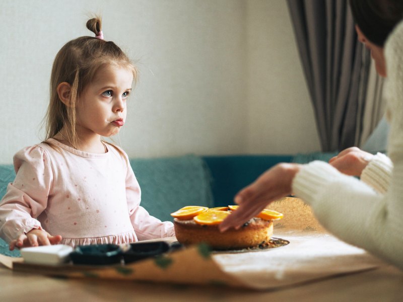 Mutter schimpft mit ihrer Tochter am Küchentisch zu Hause.