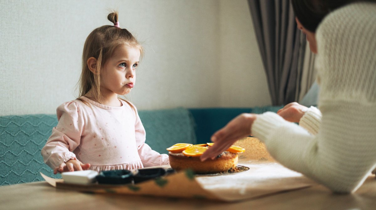Mutter schimpft mit ihrer Tochter am Küchentisch zu Hause.