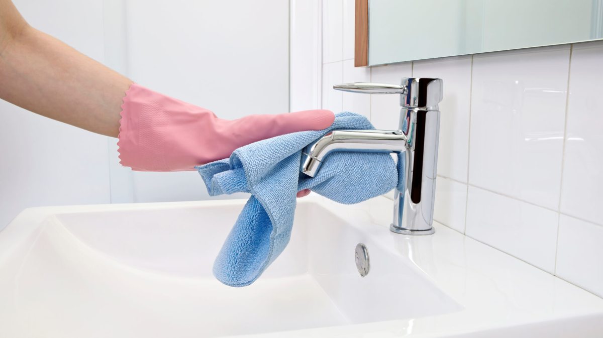 Frau putzt Badezimmer mit Tuch