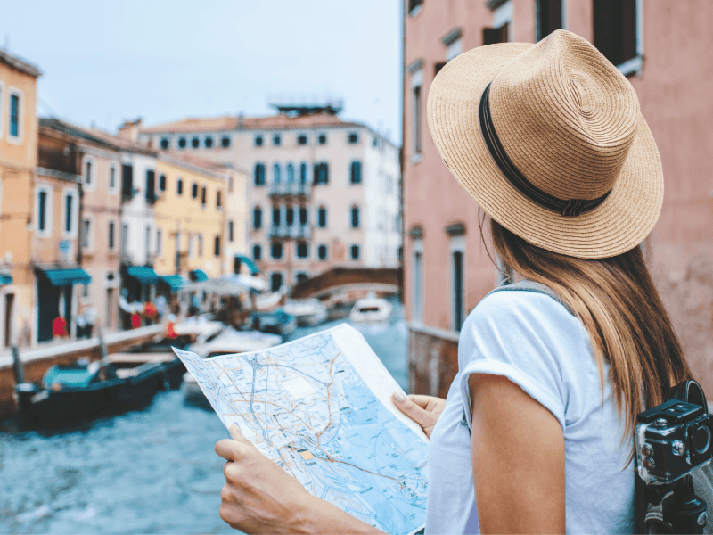 Frau mit Karte in Hand schaut sich Venedig an.