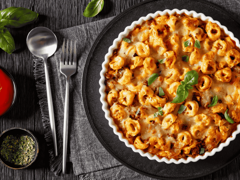 Tortelliniauflauf mit Basilikum und Tomatensoße.