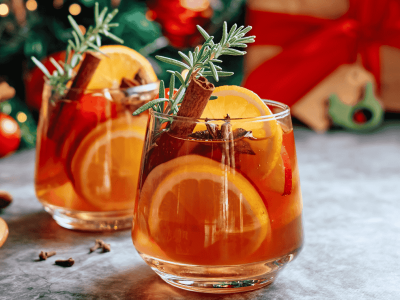 Winterliche Sangria mit Zimtstangen, Orangen und Rosmarin.