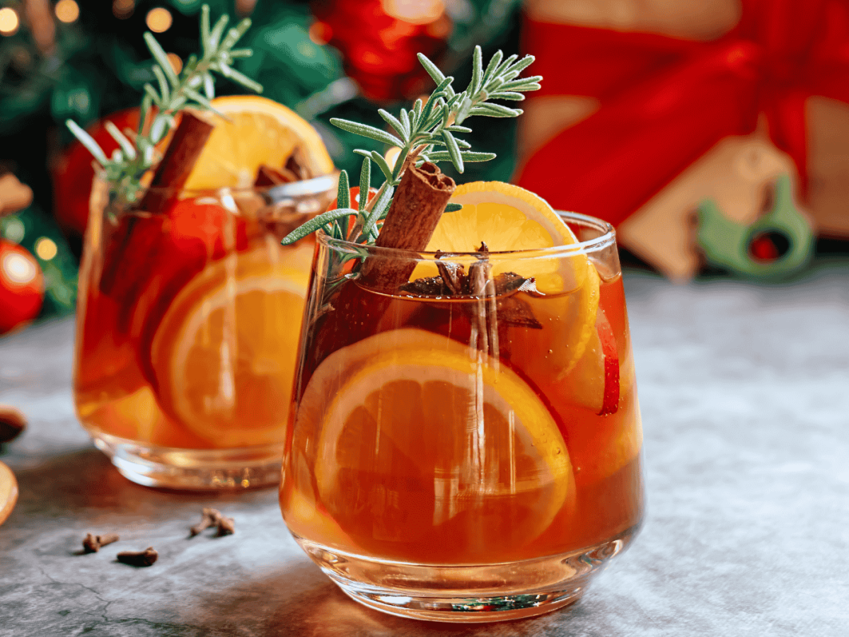Winterliche Sangria mit Zimtstangen, Orangen und Rosmarin.